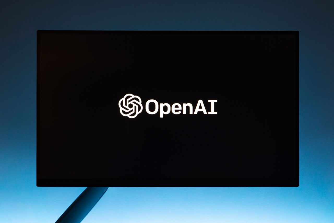 team-01 Minimalist display of OpenAI logo on a screen, set against a gradient blue background.